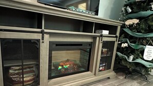 A fireplace with a decorative mantel, a Christmas tree with ornaments, and a 'Welcome' sign above it. - Skip the Steep Roads! Family Cabin Hot Tub Near PF (Sevierville)
