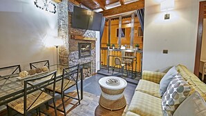 A cozy interior with a stone fireplace, a glass dining table, and a comfortable sofa. - My Special Place - An exceptional Loft (Málaga)