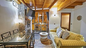 A cozy living area with a dining table, a sofa, and a stone fireplace. - My Special Place - An exceptional Loft (Málaga)