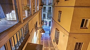A narrow alleyway between buildings with a wooden railing and a hanging light fixture. - My Special Place - An exceptional Loft (Málaga)