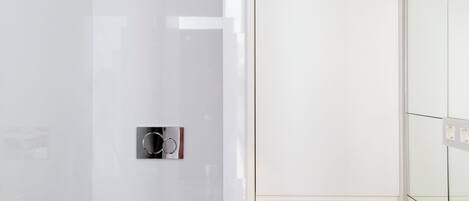 Un baño moderno con inodoro blanco, bidé y tocador de madera.