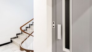 A modern interior with a marble staircase and a grey door with a window. - Genteel Home Marin Garcia IV (Málaga)