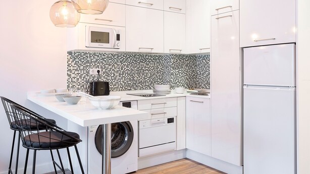 A modern kitchen with white cabinets, a microwave, a washing machine, and a refrigerator. - 1 Bd Apartment With Balcony Perfect Location. Santa Marta II (Seville)