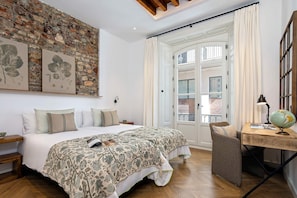 A bedroom with two beds, a desk, a globe, and botanical prints on the wall. - Genteel Home Plaza de la Marina (Málaga)