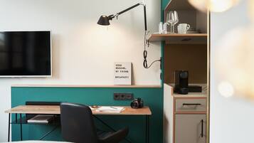 Een moderne kamer met een bureau, stoel en een tv aan de muur.