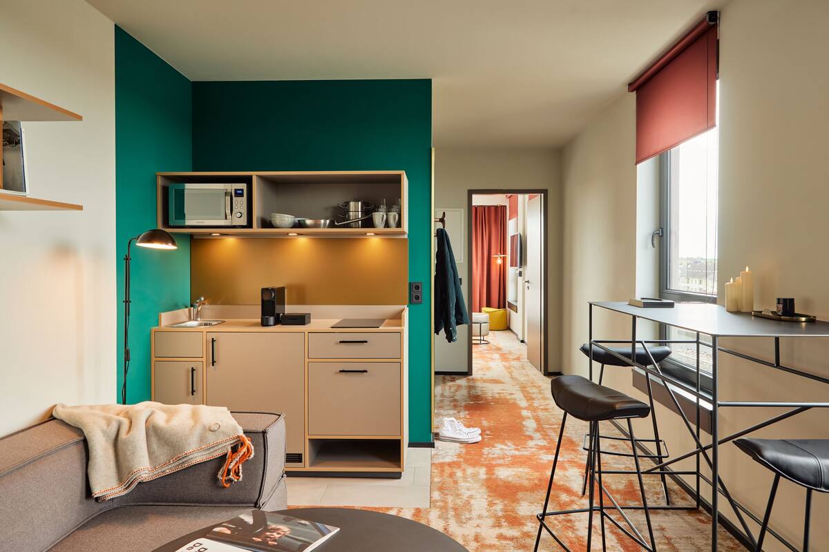 A compact living space with a kitchenette, a dining area with bar stools, and a cozy seating area.