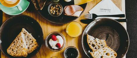 Un desayuno con diversas comidas y bebidas sobre una mesa de madera.
