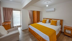 Quarto com cama de madeira, mesa de cabeceira de madeira, cadeira de madeira, escrivaninha de madeira e janela com cortinas.