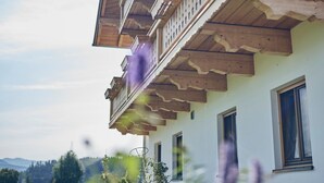 Ein traditionelles Holzhaus mit Balkonen, Fenstern und Blick auf die umliegende Landschaft.