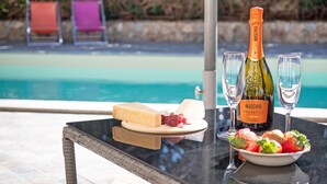 Una mesa con una botella de Maschio Prosecco, dos copas, un plato de queso y uvas, y un bol de fresas.