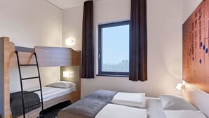 A hotel room with a bunk bed, a single bed, and a window with curtains. - B&B Hotel Köln-Troisdorf (Troisdorf)