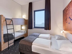 A hotel room with a bunk bed, a single bed, and a window with curtains. - B&B Hotel Köln-Troisdorf (Troisdorf)