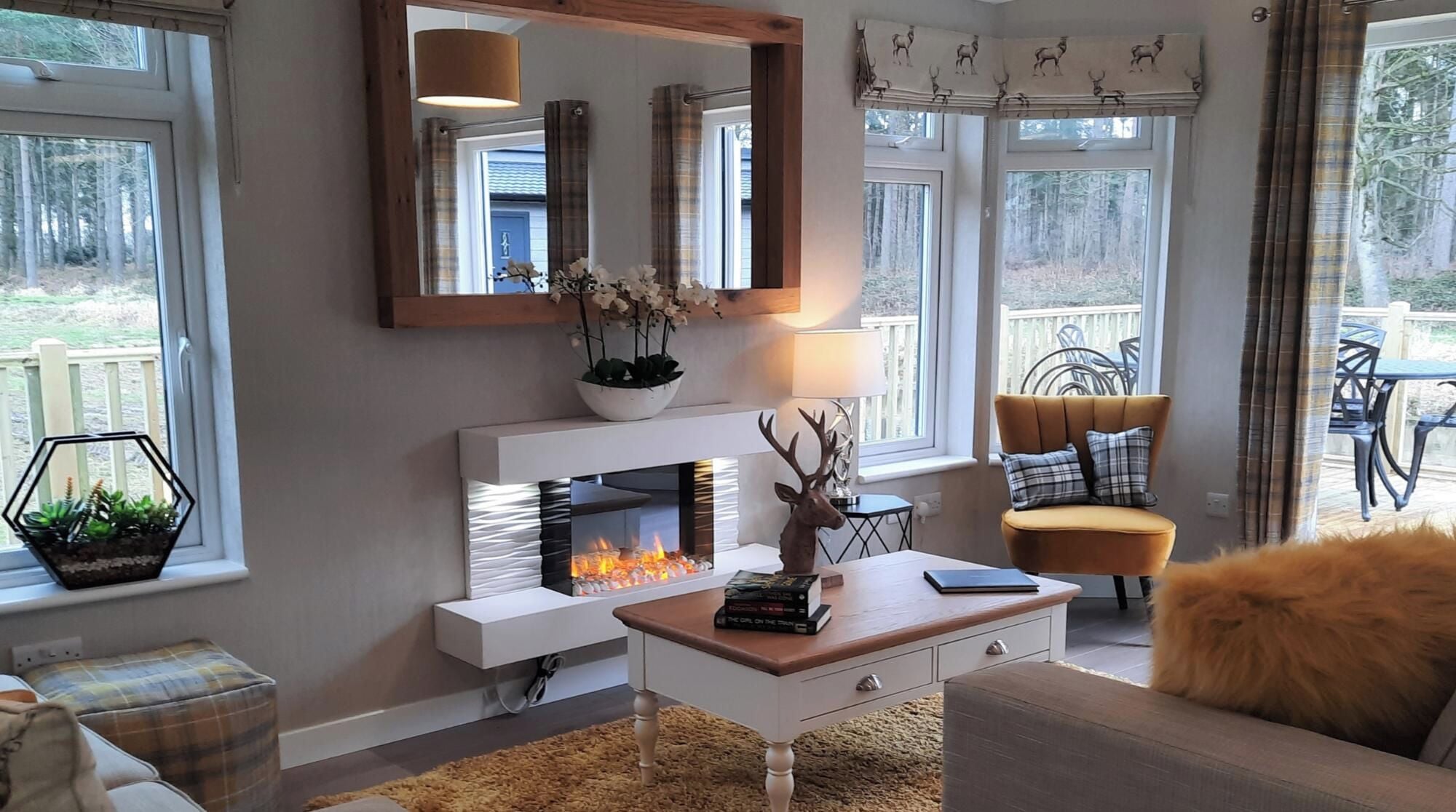 A living room with a fireplace, a sofa, a coffee table, and a dining area with outdoor seating.