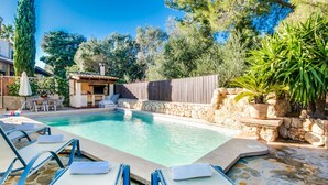 A swimming pool with lounge chairs and a barbecue area. - House in Alcudia Can Jaume with swimming pool (Alcúdia)