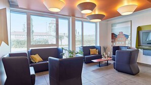 Un moderno salón con sofás de cuero, una mesa de centro y grandes ventanales con vistas a la ciudad.