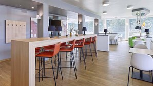 Una cocina moderna con una isla desayunadora, taburetes de bar e iluminación colgante.