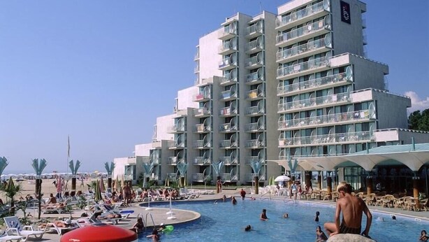 Un hotel con un amplio espacio de piscina, varios balcones y un diseño arquitectónico moderno.