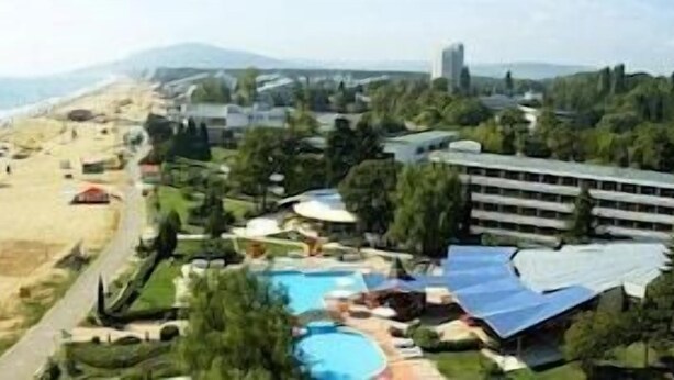Un resort con playa, piscina y varios edificios.