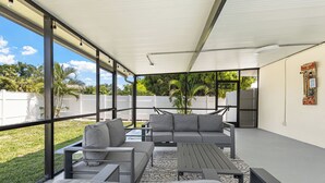 An outdoor patio with a sofa, chairs, and a table. - Luxury Living & Heated Pool Near Anna Maria Island (Bradenton)