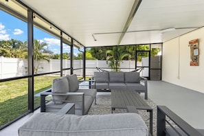 An outdoor patio with a sofa, chairs, and a table.