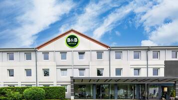 A B&B hotel with a modern facade, large windows, and a covered entrance.
