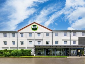 A B&B hotel with a modern facade, large windows, and a covered entrance.
