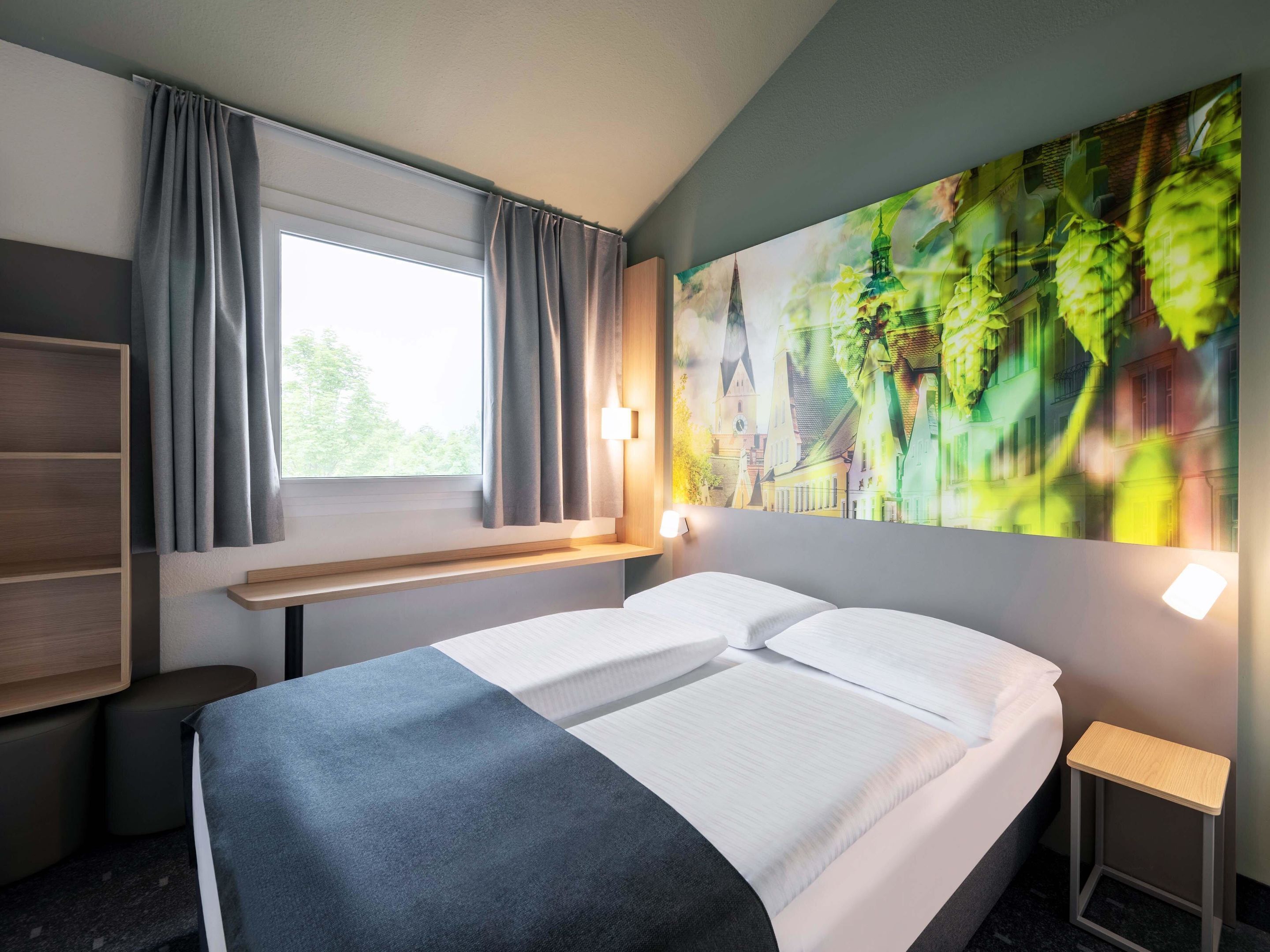 Ein Hotelzimmer mit Bett, einem Vorhangfenster, einer Wandregal und einem Gemälde.