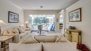 Un salon avec un canapé, une table basse, un téléviseur et un meuble.