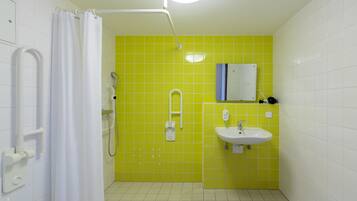 Une salle de bain avec une douche, un lavabo et un miroir.