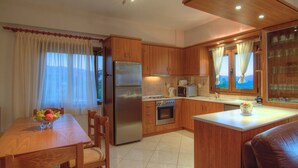Una cucina compatta con mobili in legno, un frigorifero, un forno a microonde e un piccolo forno.