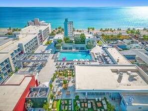 Relax by the rooftop pool surrounded by lounge chairs and umbrellas, with the beach just steps away.