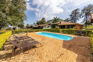A pool area with lounge chairs, a brick patio, and a clear blue sky. - Stables 90 minutes from São Paulo (Cesário Lange)