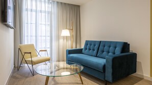 A modern living room with a blue sofa, a yellow chair, and a glass coffee table. - Tandem Portal de Elche (Alicante)