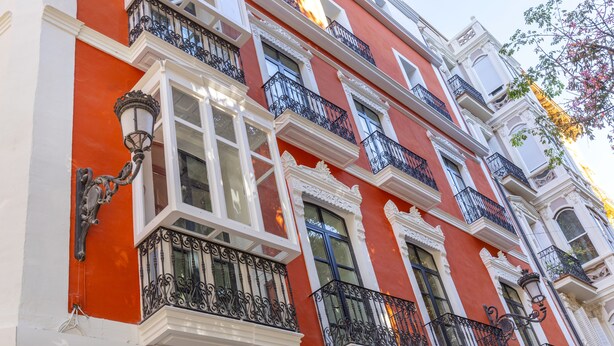 A multi-story building with ornate balconies and white window frames. - Tandem Portal de Elche (Alicante)
