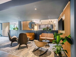 Una sala de estar moderna con sofá, sillones, una mesa de centro y televisor.