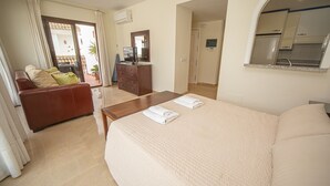 A hotel room with a bed, a sofa, a desk, and a kitchenette. - Marina Real apto 534 (Manilva)