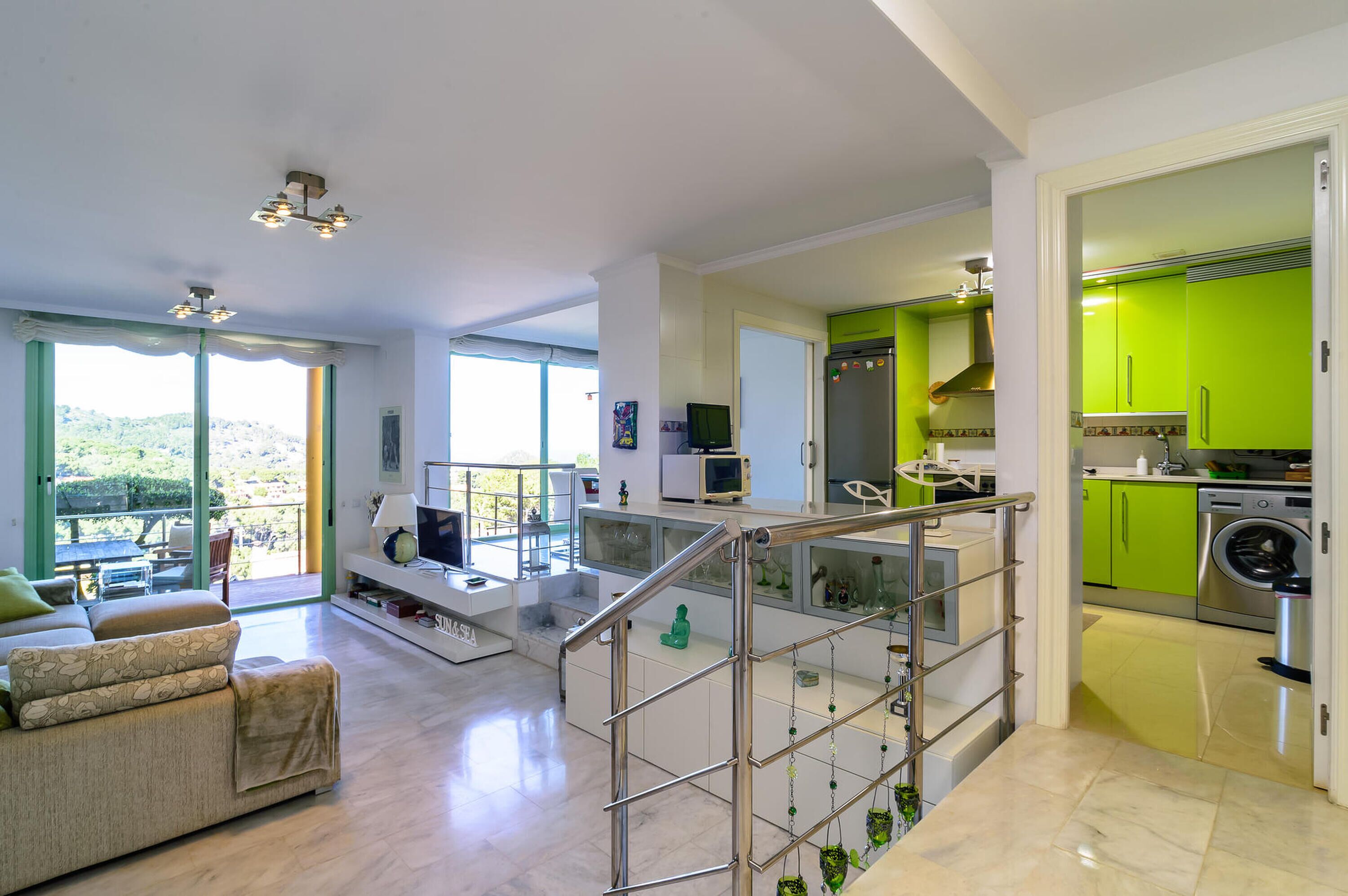 A modern apartment with a living area, kitchen, and balcony.