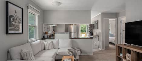A modern living room with a sofa, a coffee table, and a TV stand.