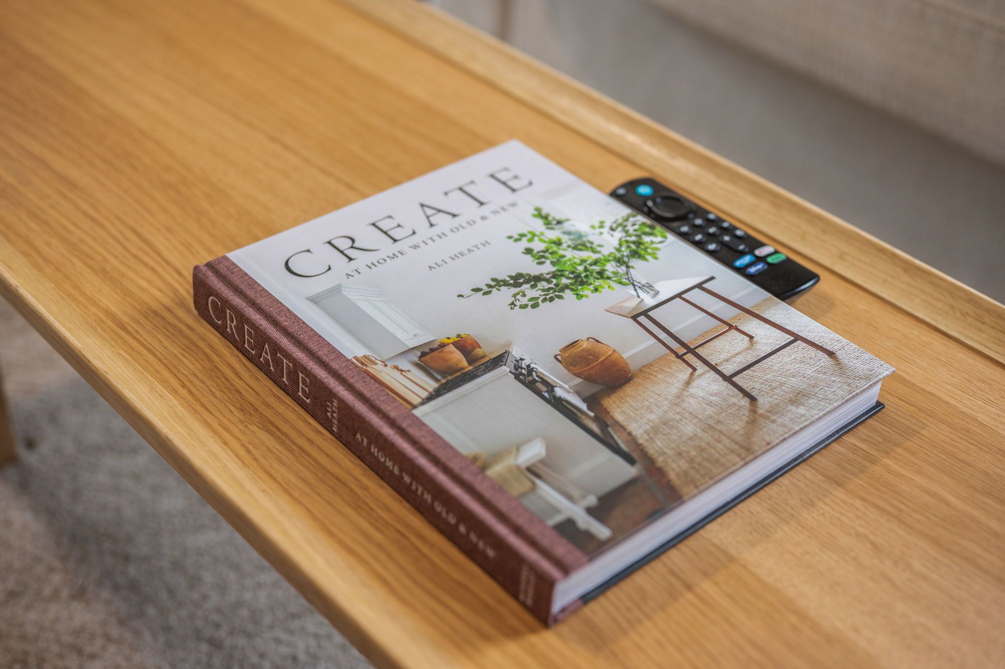 A book titled 'CREATE AT HOME WITH OLD & NEW' on a wooden table.