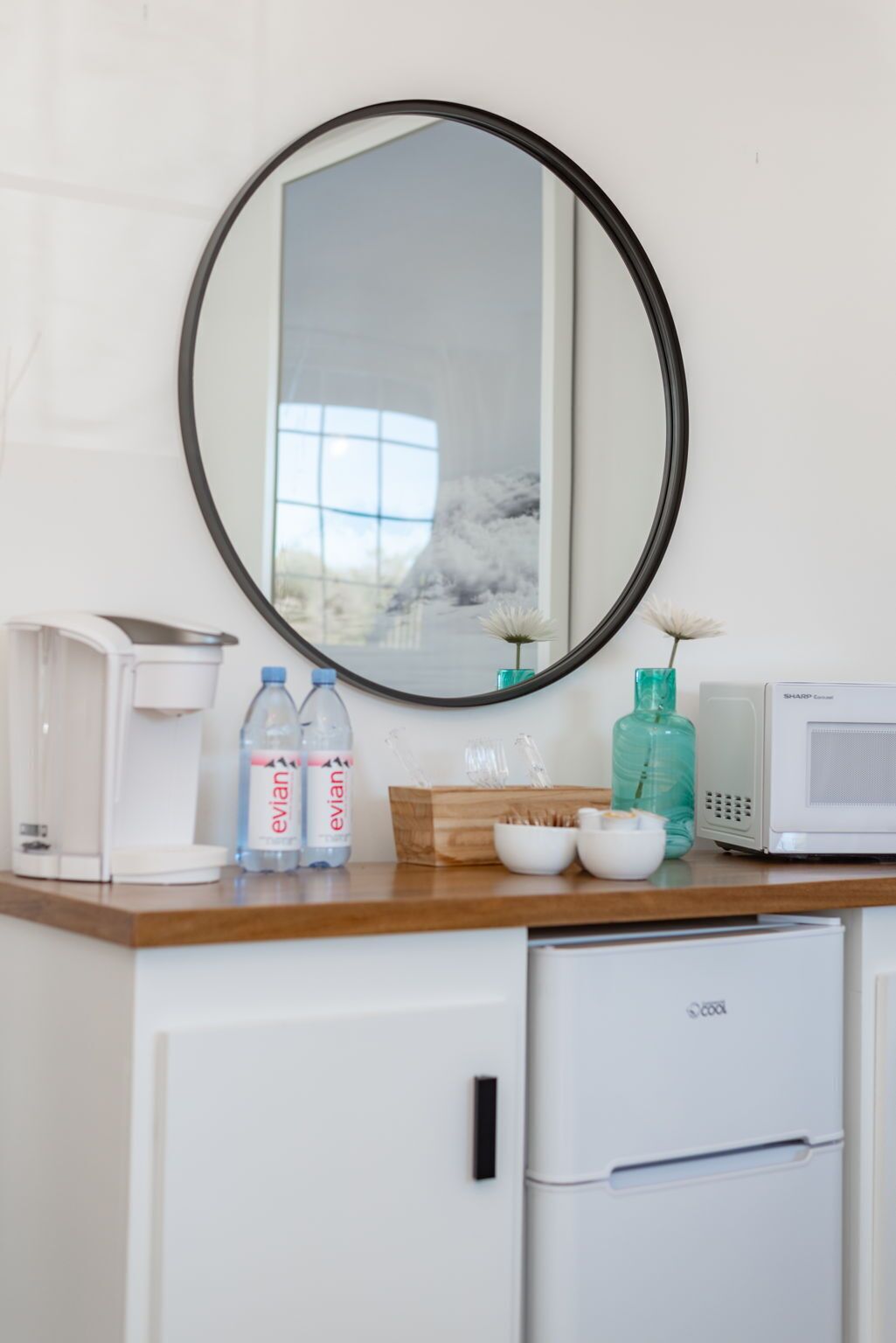 Una kitchenette equipada con microondas, cafetera y un armario.
