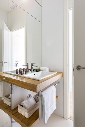 A modern bathroom with a wooden vanity, a large mirror, and a white sink. - Genteel Home Francos Entretejas II (Seville)