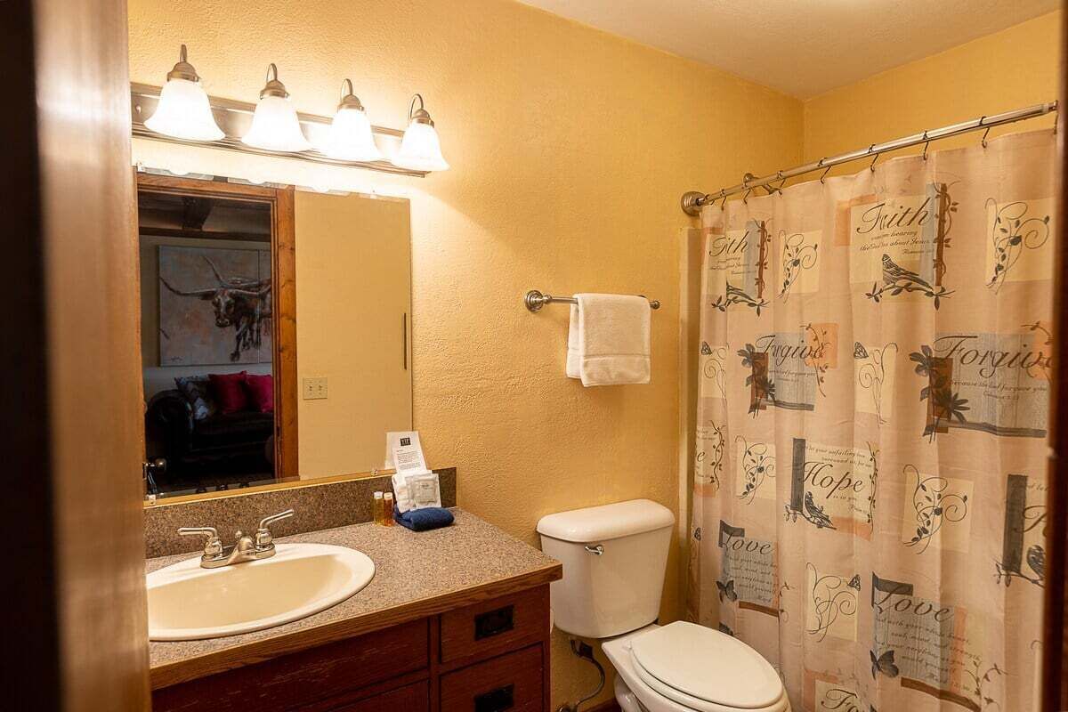 Ein Badezimmer mit Waschbecken, Spiegel und Toilette.