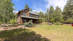A log cabin with a porch and a grassy yard. - Hot Tub! Secluded Cabin, overlook Lake Pagosa on 39 acres, No Neighbors! (Pagosa Springs)