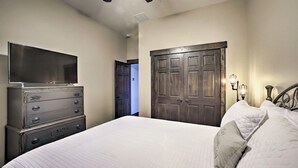 A bedroom with a bed, a dresser, a television, and a wardrobe.