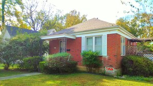 A single-story brick house with a front porch and a 'For Sale' sign. - Urban Retreat on Flint in the Heart of Jonesboro (Jonesboro)