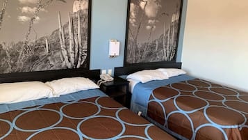 A hotel room with two beds, a nightstand, and a wall-mounted phone.