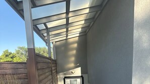 A covered stairway leading to a door with a glass panel, a metal handrail, and a wooden fence in the background. - Location, comfort and cleanliness.<br>Whole basement 1600-plus square feet.  (LEHI CITY)