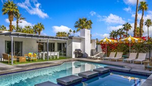 A pool area with lounge chairs, a barbecue, and a covered seating area with umbrellas. - Paloma House - Mid century style with Frida Kahlo Soul (Palm Springs)