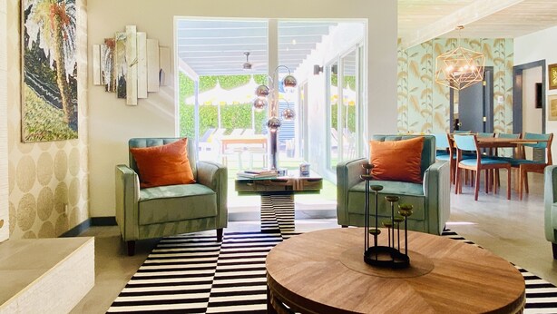 A modern living room with two green armchairs, a black and white striped rug, and a wooden coffee table. - Paloma House - Mid century style with Frida Kahlo Soul (Palm Springs)