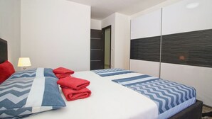 A hotel room with a bed, pillows, a lamp, and a wardrobe. - ESMA 2 - Deluxe Apartment (Rovinj)